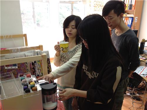 Karen shows Sylvania how to use the Nespresso machine