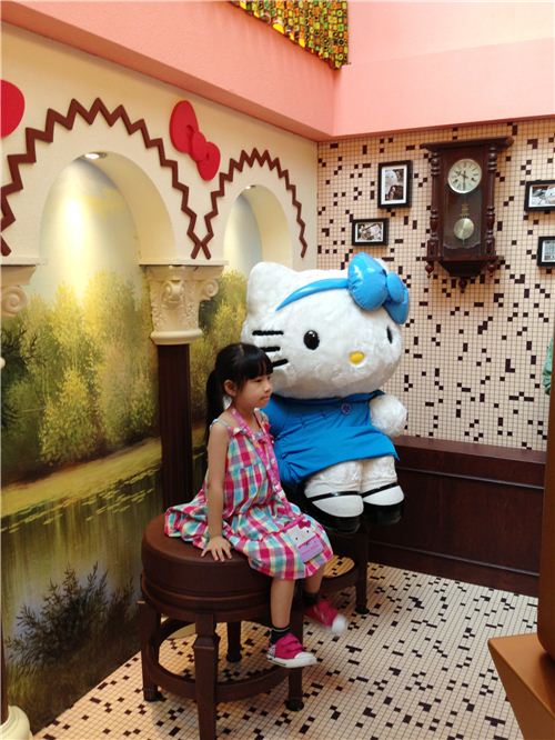A little girl posing with Hello Kitty in a photo studio. Family portraits are a huge thing in Chinese culture