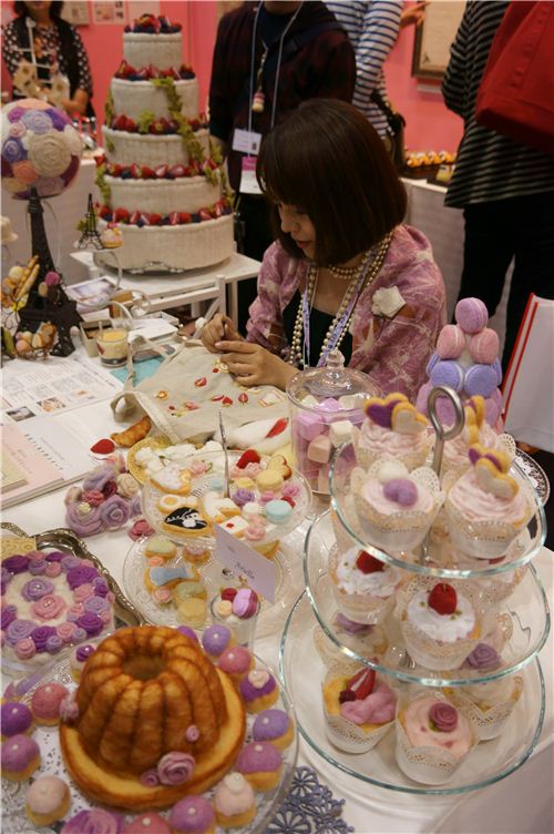 A woman surrounded by clay sweets