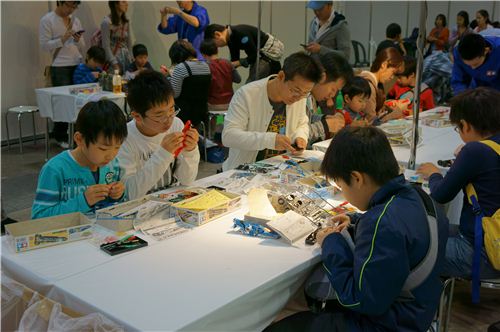 Some children are assembling miniature items